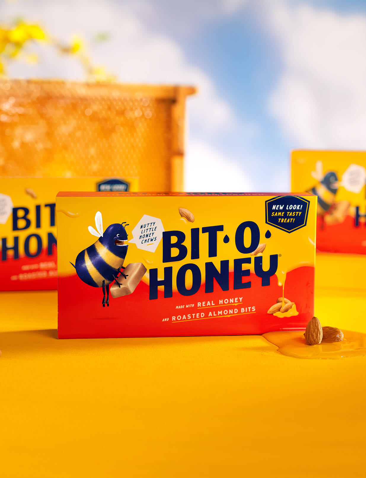 Two boxes of Bit-O-Honey candies sit in front of a honeycomb